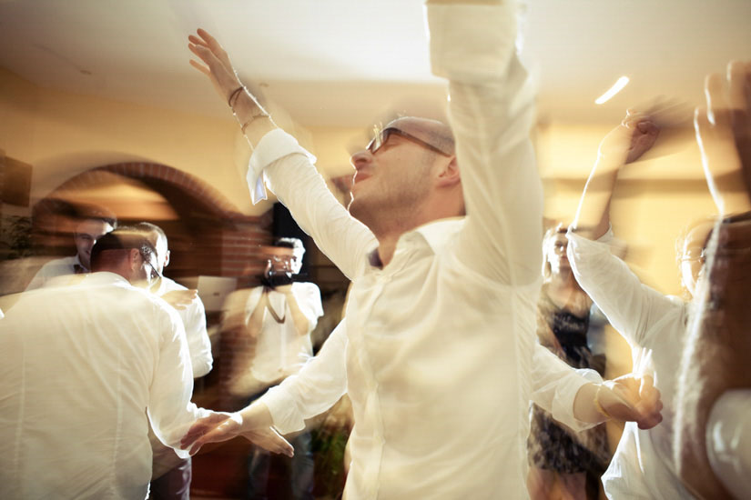 Fotografo matrimonio Torino: il testimone balla con le mani al cielo