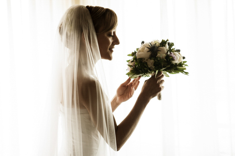 Fotografo matrimonio Torino: una sposa odora elegante il suo bouquet fiorito